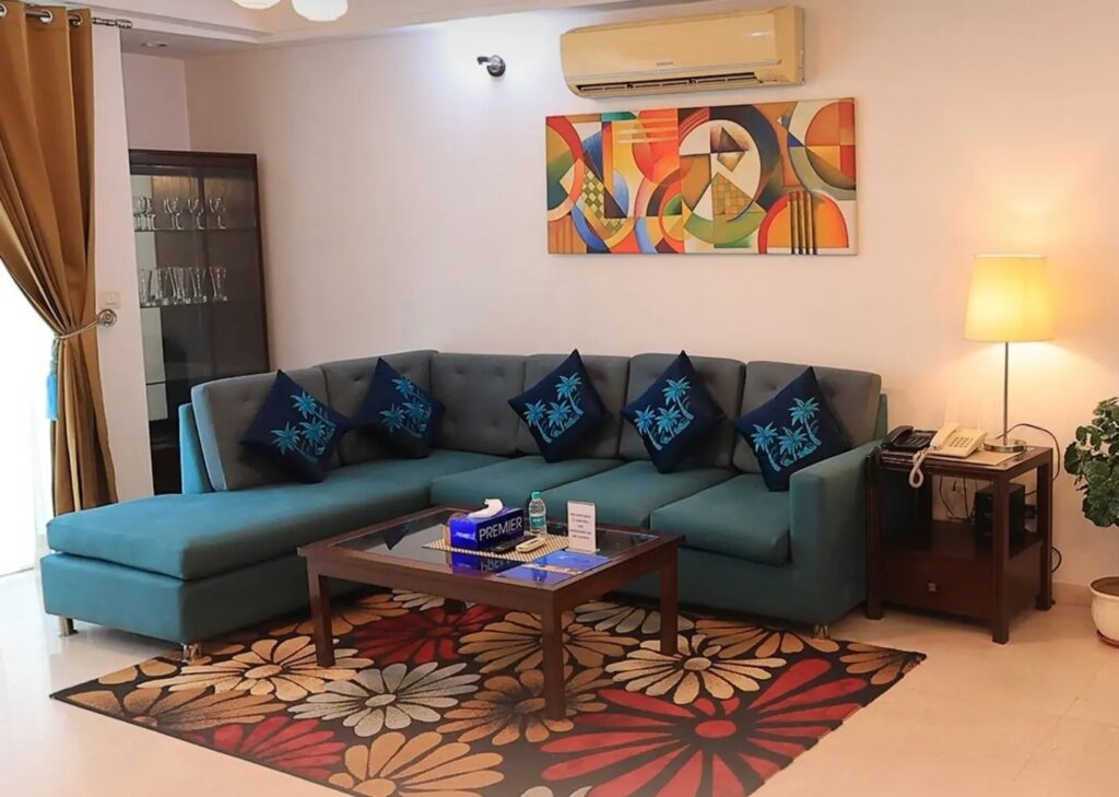 Enkay serviced apartment living room with a spacious sofa, coffee table and modern interiors.
